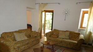 A living room with two floral-patterned sofas, a small wooden coffee table, and a patterned rug.
