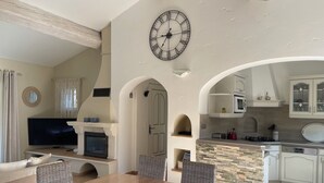 A modern kitchen with white cabinets, a stone backsplash, and a large clock on the wall. - Air-conditioned villa, 4-star rating, Ste-Maxime residential area, golf view (Sainte-Maxime)