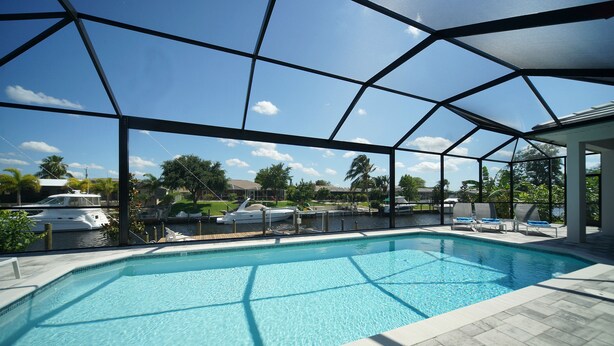 Piscina com vista clara do céu e um cais com barcos.