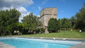 A swimming pool with a stone building in the background.