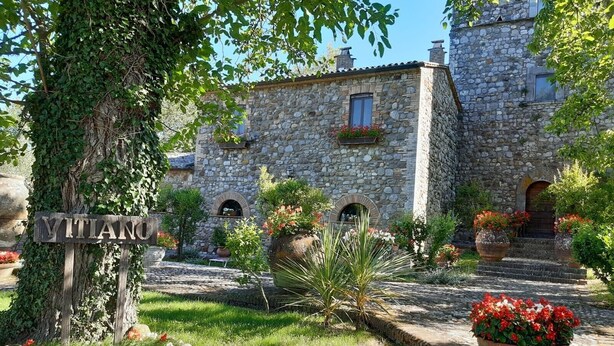 A stone building with a sign reading "VITTANO".