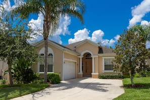 A two-story house with a beige facade, a front garage, and a well-maintained lawn. - 4 Bedroom Executive Villa with Pool & Spa, Games Room, Wifi and Large Garden
(Davenport)