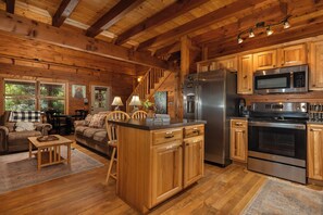 A log cabin interior with a kitchen, dining area, and living room. - Hurricane Hideaway*Hot Tub*Game Rm*Views*PetsOK (Deep Gap)
