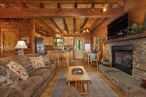 A log cabin interior with a living room, kitchen, dining area, and fireplace. - Hurricane Hideaway*Hot Tub*Game Rm*Views*PetsOK (Deep Gap)