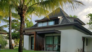 A modern house with a flat roof, large windows, and a well-maintained lawn. - PORTO DE GALINHAS BANGALO PREMIUM AT THE BEACH CLASS HOTEL (ipojuca)