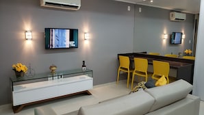 A modern bathroom with a glass vanity, a mirror, and yellow chairs. - PORTO DE GALINHAS BANGALO PREMIUM AT THE BEACH CLASS HOTEL (ipojuca)