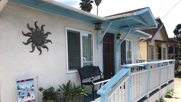 A house with a porch, a welcome sign, and a mailbox.