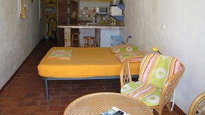 A compact room with a bed, a chair, a small table, and a kitchenette. - Small studio with all mod cons and a large shared pool (Lorgues)