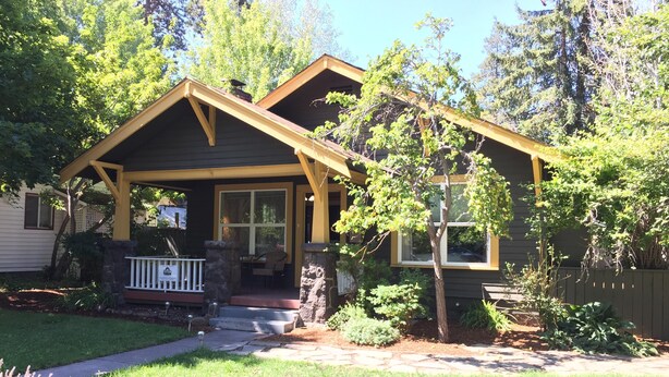 A two-story house with a front porch, a stone staircase, and a well-maintained lawn. - Elderberry- Salt Hot Tub, Wood Fireplace, 100+mbps Wifi, Walkable to Downtown (Bend)