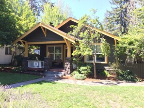 A two-story house with a front porch, a stone staircase, and a well-maintained lawn. - Elderberry- Salt Hot Tub, Wood Fireplace, 100+mbps Wifi, Walkable to Downtown (Bend)