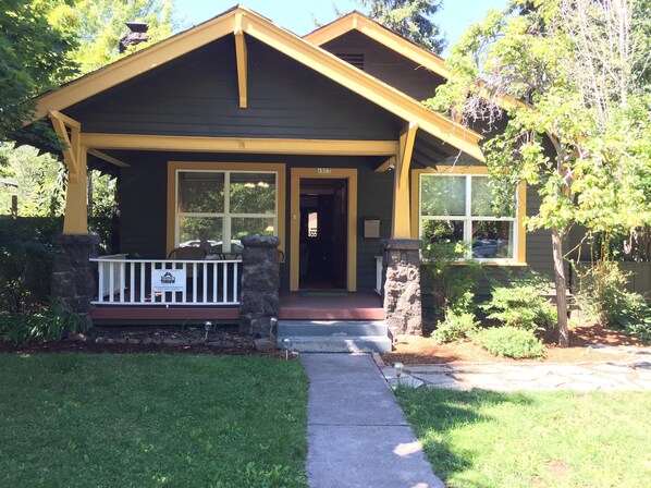 A two-story house with a front porch, stone pillars, and a mailbox. - Elderberry- Salt Hot Tub, Wood Fireplace, 100+mbps Wifi, Walkable to Downtown (Bend)