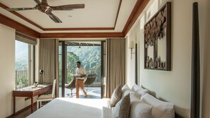 A hotel room with a large bed, a desk, and a balcony with a view of the mountains. - Niraamaya Retreats Samroha Athirappilly (Chalakudy)