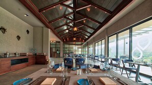 A spacious dining area with a high ceiling, large windows, and a modern interior design. - Niraamaya Retreats Samroha Athirappilly (Chalakudy)