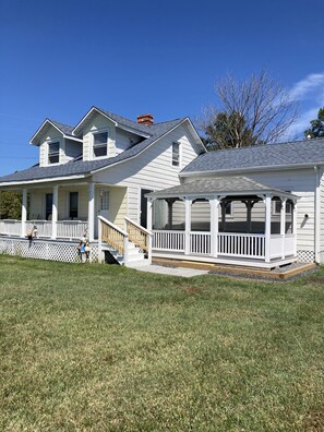 A two-story house with a covered porch and a fenced yard.