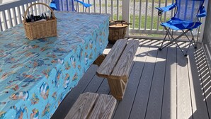 A covered outdoor deck with a picnic table, blue chairs, and a basket of utensils. - BEAUTIFUL PEACEFUL, SCENIC, ENJOY CRABS N FISH MEMORABLE, FREE TOUR OF AREA! (Fishing Creek)
