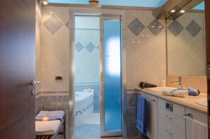 Une salle de bain moderne avec une douche à parois de verre, une baignoire et un meuble-lavabo avec un miroir.