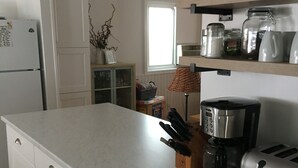 A modern kitchen with a large island, built-in appliances, and a variety of storage options.