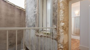 A narrow stairway with a metal railing, a rough stone wall, and a wooden floor. - Parfum - First concierge service (Montpellier)