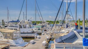 A marina with multiple boats docked at wooden piers. - Starboard at Captain's Bridge (Southport)