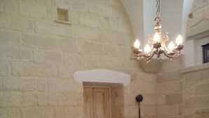 A room with a bed, a chair, a wardrobe, and a chandelier.