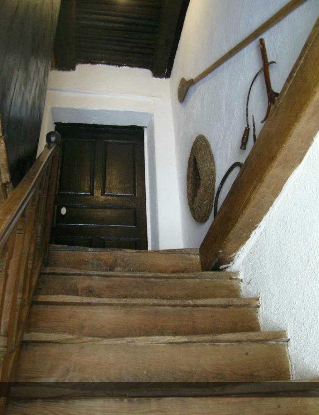 Una escalera de madera que conduce a una puerta oscura.