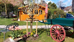 A wooden house with a porch, a garden with flowers, and a vintage carriage. - 3 *** apartment in the comfort of a thatched old farmhouse from 1746 (Cuxhaven)