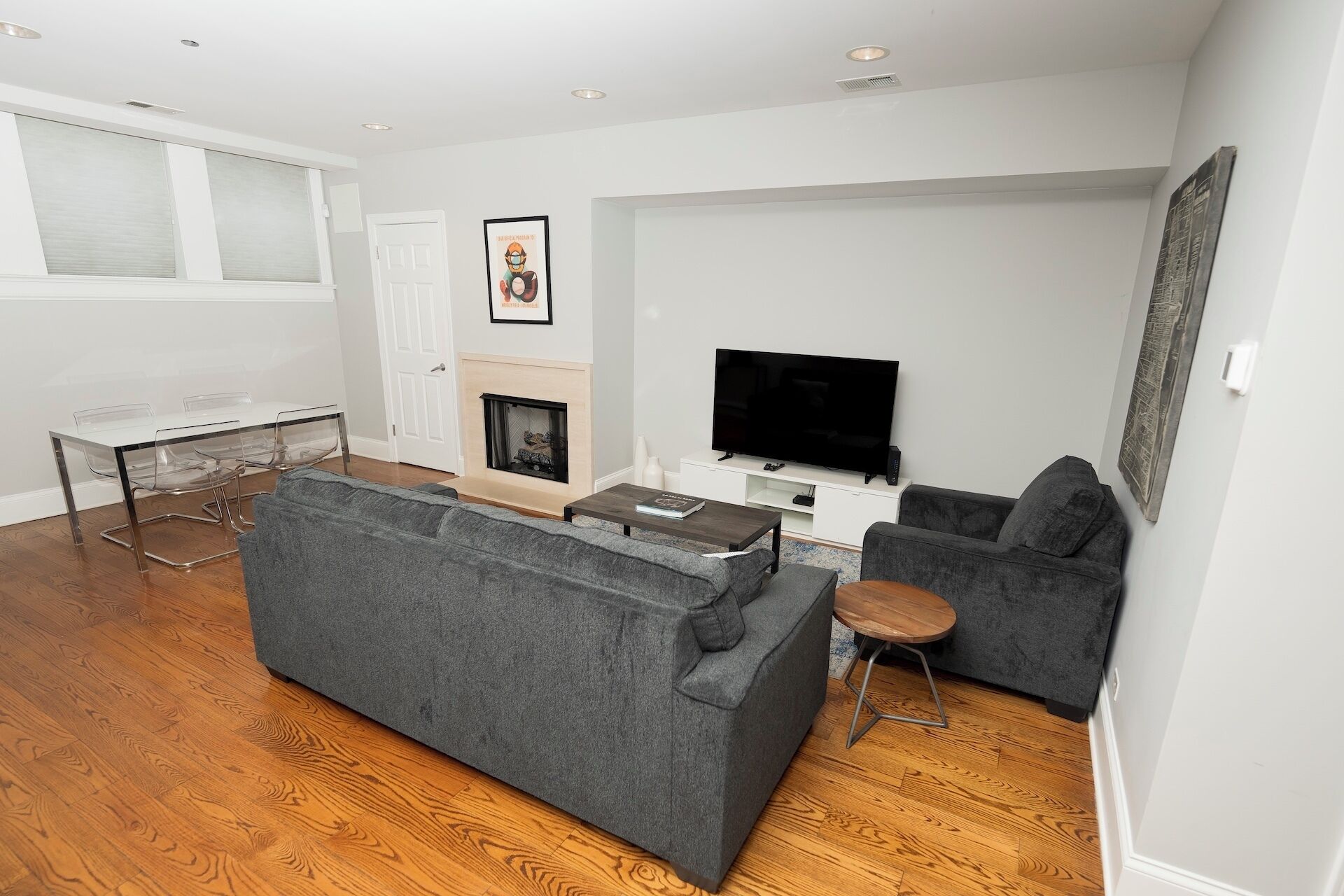 A modern living room with a grey sofa, a small coffee table, a TV, and a fireplace.