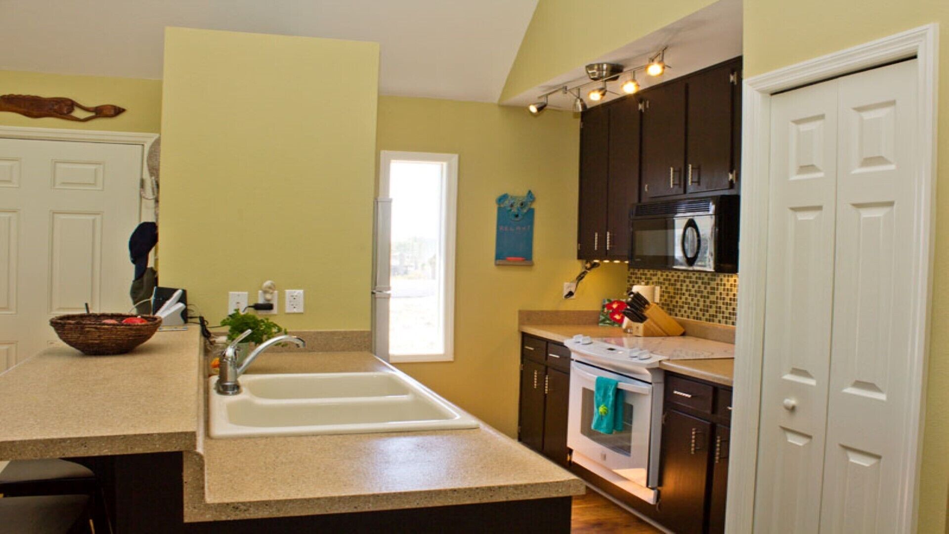 A kitchen with a large island, a sink, a stove, and cabinets.