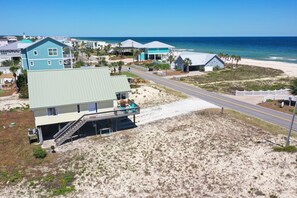 A coastal property with a large house featuring a balcony, a staircase leading to the entrance, and a view of the beach and ocean. - AMAZING VIEW! Fun, Pets Welcome, Steps from Beach (St George Island)