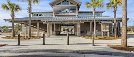 A modern building with a covered entrance, palm trees, and a bike parked outside.