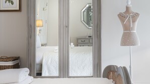 A bedroom with a large mirror, a chandelier, a dresser, and a mannequin. - Shrubbery Mews 5 * Apt 2 (Kenmare)