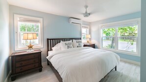 Une chambre à coucher avec un lit, des tables de chevet et des fenêtres.