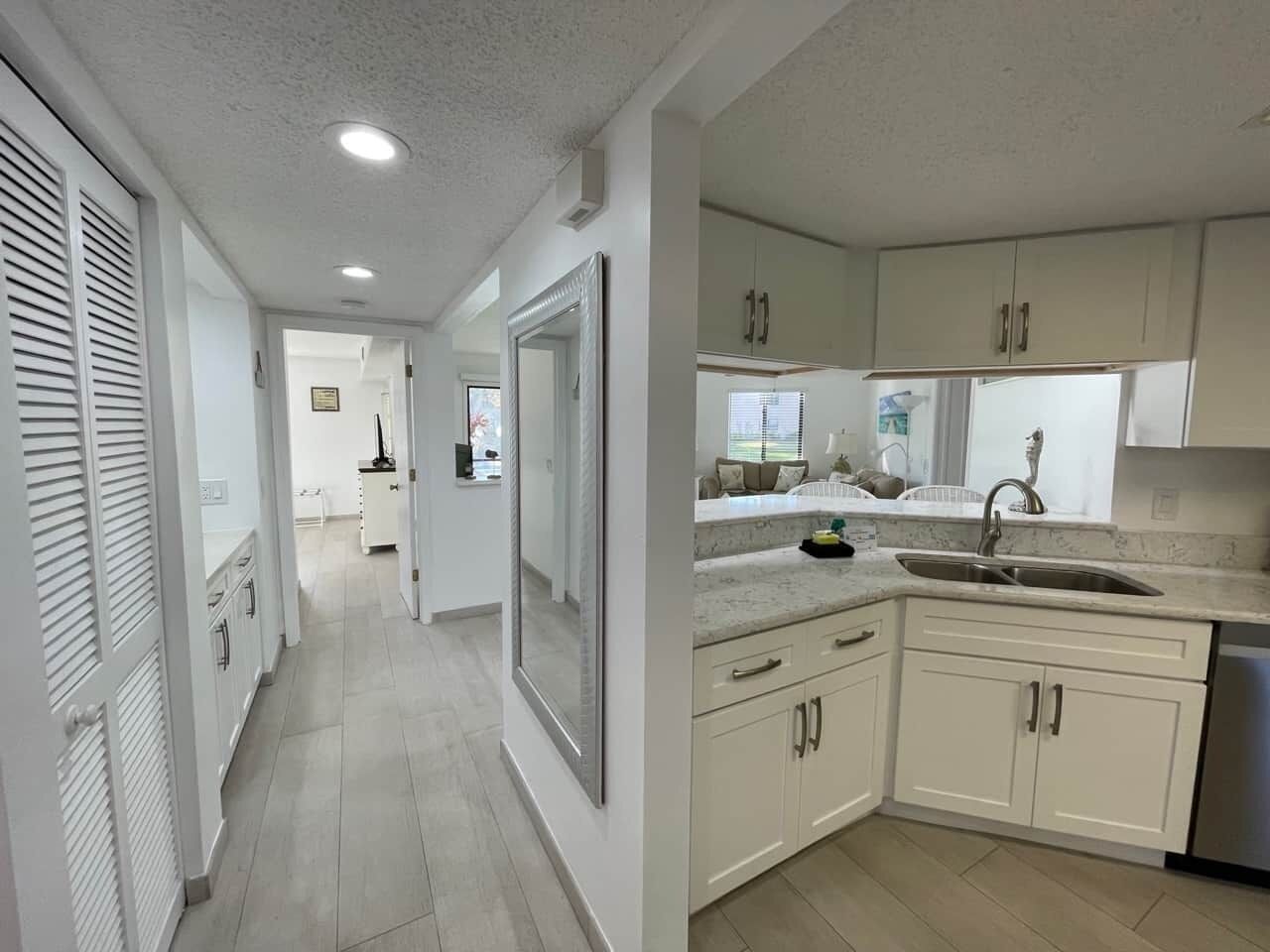 A modern kitchen with white cabinets, a sink, and a countertop.