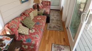 A cozy living room with a floral sofa, a small table, and a lamp.