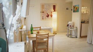 Une cuisine moderne comprenant un coin repas, un réfrigérateur, un évier et une table avec des chaises.