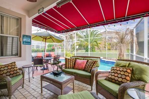 Un espace extérieur aménagé avec des meubles en osier, une piscine et une vue sur le paysage.