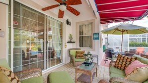 A covered patio area with wicker furniture, a ceiling fan, and a red awning. - EV_536 - 4BR / 2BA Highlands Reserve Villa near Disney, Private Pool (Davenport)