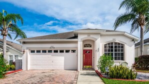 A single-story house with a white exterior, a red front door, and a garage numbered 536. - EV_536 - 4BR / 2BA Highlands Reserve Villa near Disney, Private Pool (Davenport)