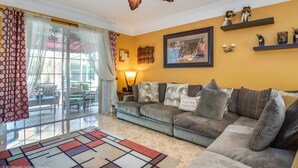 A living room with a gray sofa, patterned rug, and a ceiling fan. - EV_536 - 4BR / 2BA Highlands Reserve Villa near Disney, Private Pool (Davenport)