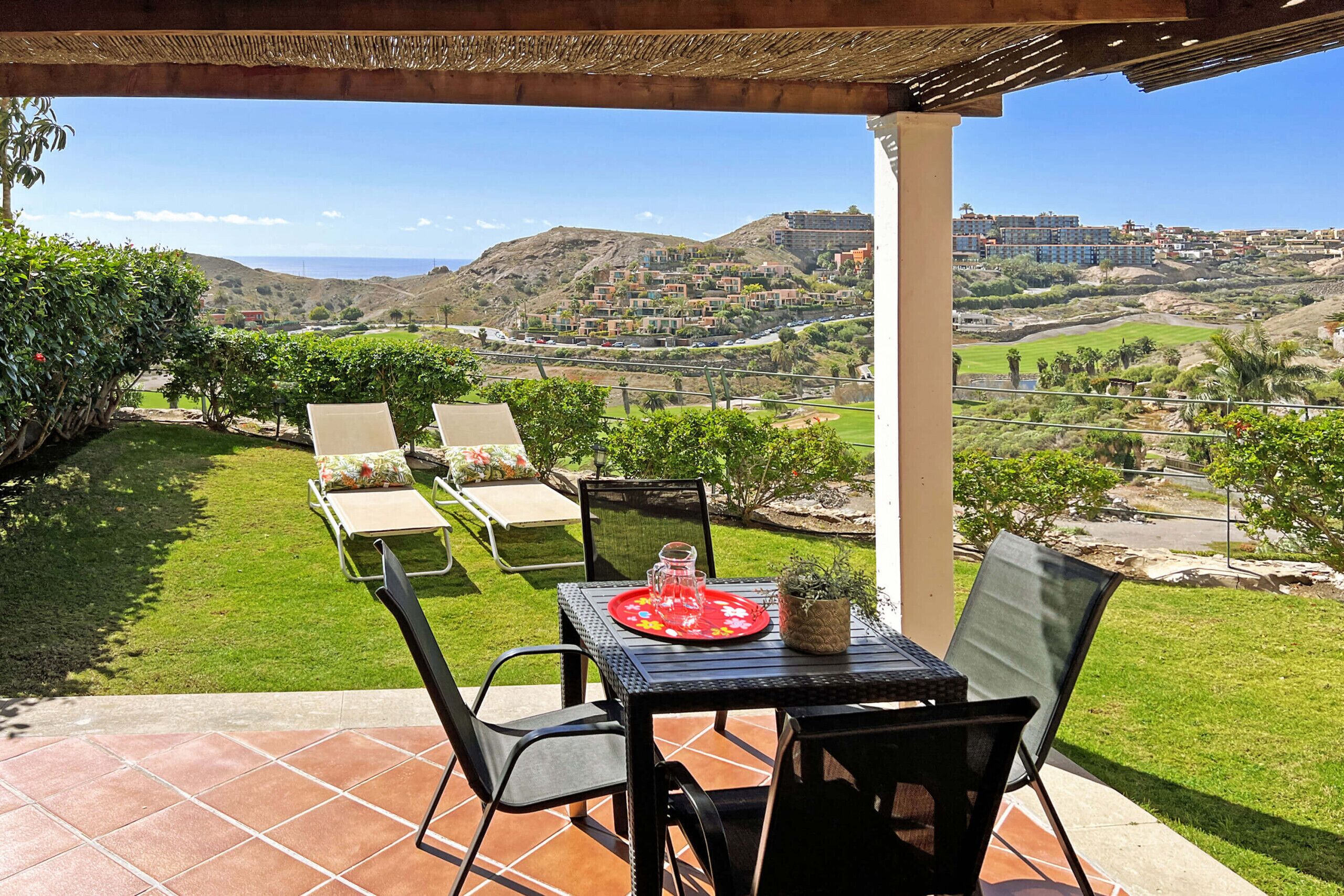 Une terrasse avec une table dressée pour deux personnes, offrant une vue panoramique sur une colline pittoresque.