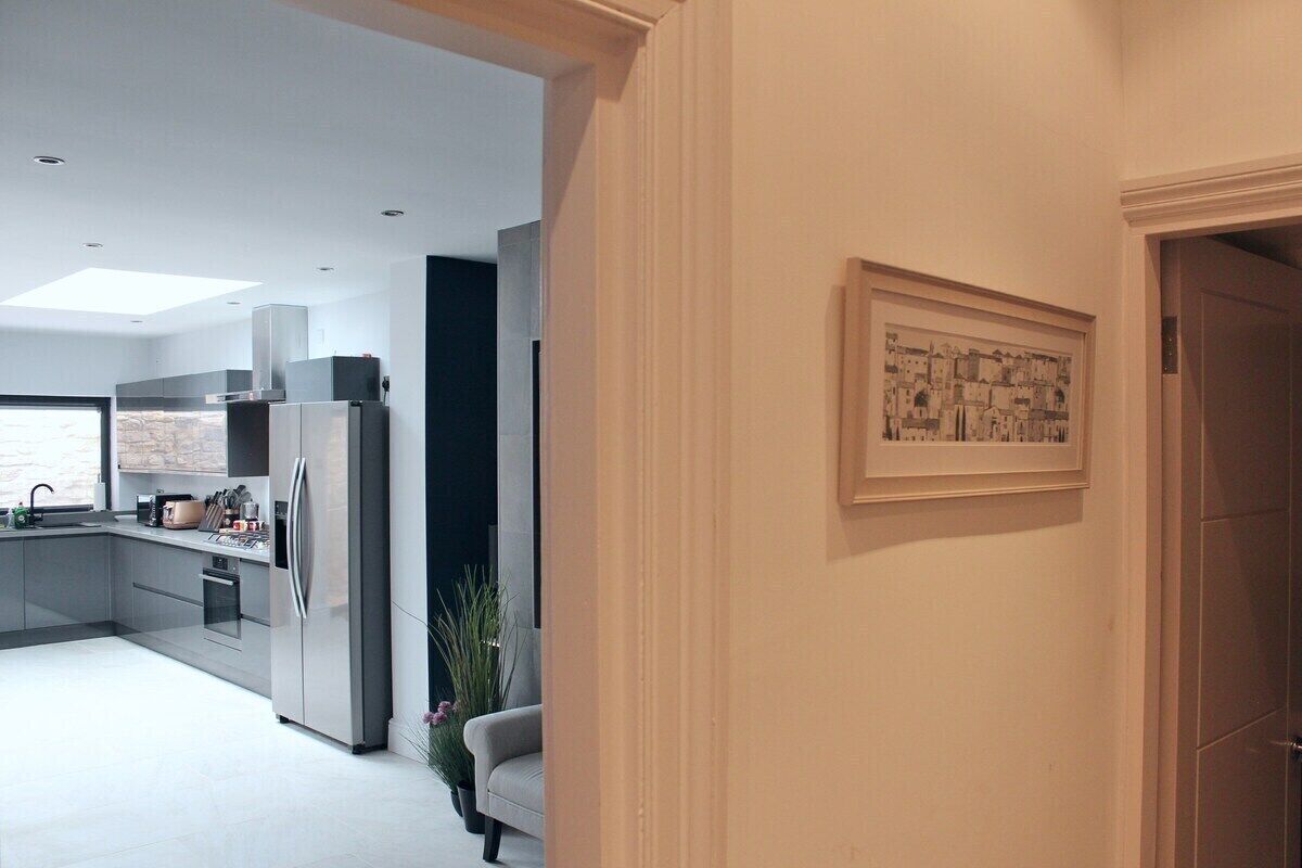 A modern kitchen with stainless steel appliances, a built-in oven, and a large window.
