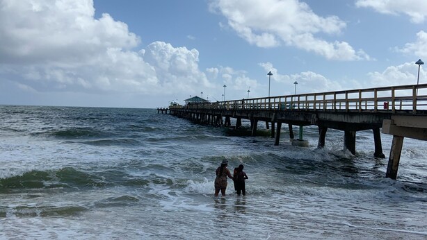 A beach with a pier extending into the ocean, featuring a walkway and a small structure at the end. - 1 Bedroom Suite in a duplex house- private heated pool for you- walk to beach  (Lauderdale-By-The-Sea)