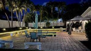 An outdoor patio with a pool, seating area, and a covered dining area. - 1 Bedroom Suite in a duplex house- private heated pool for you- walk to beach  (Lauderdale-By-The-Sea)