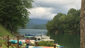A lakeside dock with canoes and a wooden walkway.