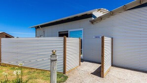A metal building with a corrugated exterior, a wooden door, and a sign that reads "CABANA".
