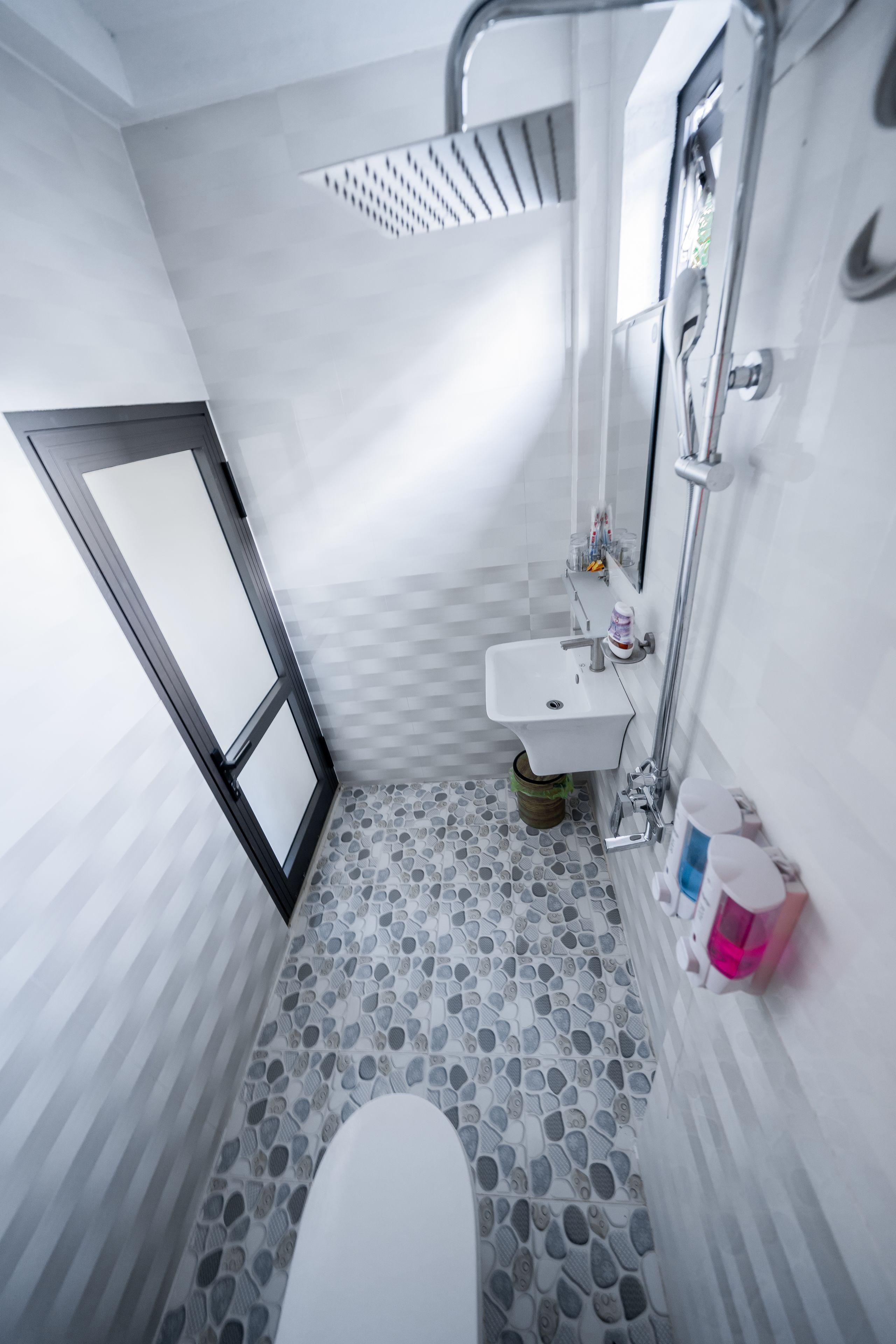 A bathroom with a white sink, a toilet, and a shower area.