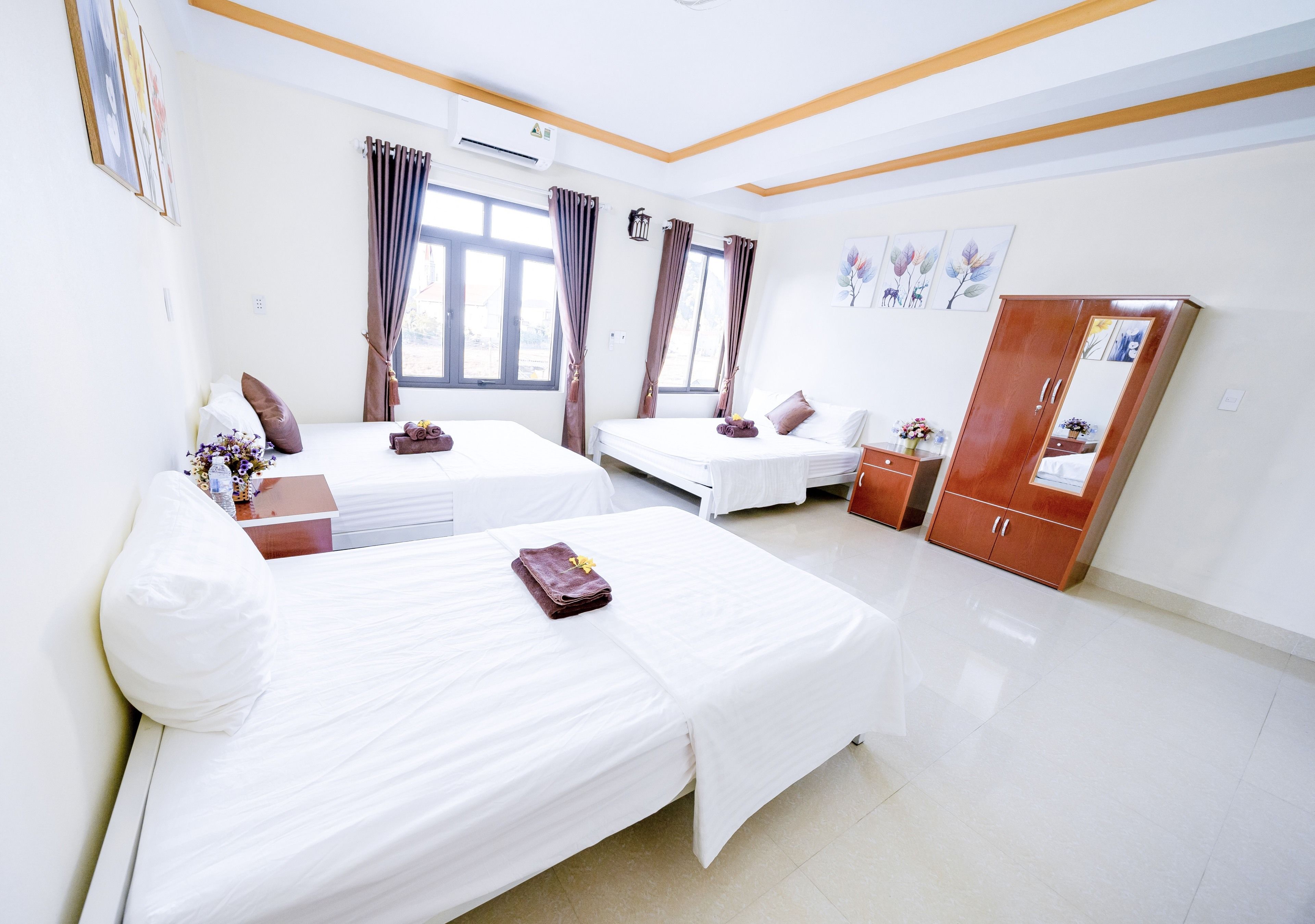 A hotel room with two beds, a wardrobe, and a window with curtains.