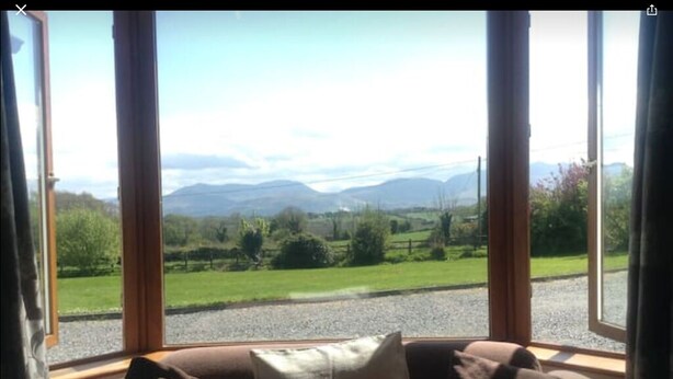 Una habitación con un gran ventanal que ofrece vistas a un paisaje verde y montañas.