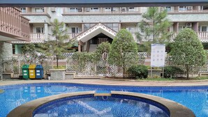 A swimming pool with a hot tub, surrounded by a fence and trees. - SweetSuites at Pine Crest New Manila / #T3-1012 (Quezon City)