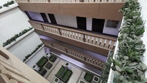 A multi-level building with balconies, green plants, and a modern architectural design. - SweetSuites at Pine Crest New Manila / #T3-1012 (Quezon City)